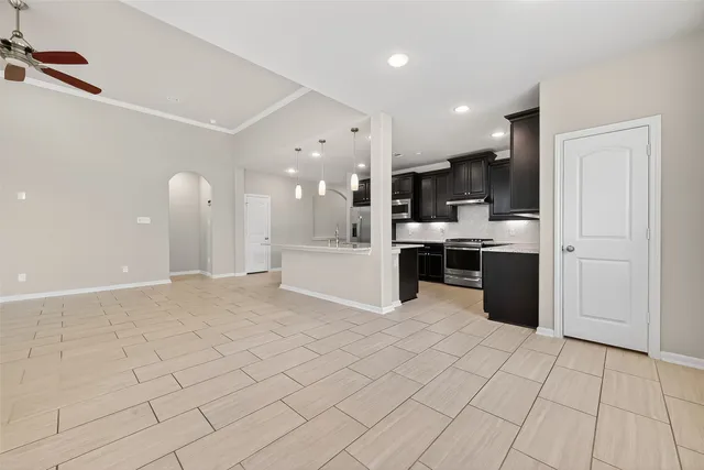 a kitchen with stainless steel appliances kitchen island granite countertop a refrigerator and a stove top oven