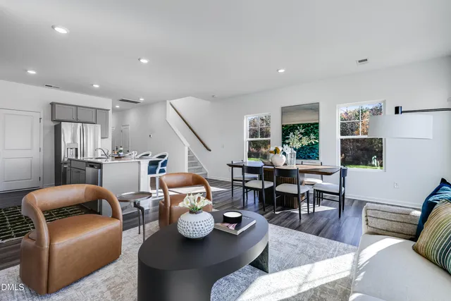 a living room with furniture kitchen view and a table