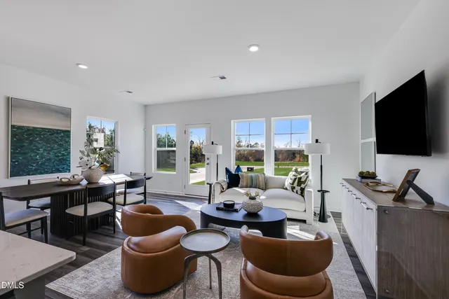 a living room with furniture a flat screen tv and a large window