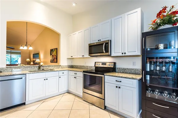 a kitchen with stainless steel appliances granite countertop a stove a sink and a microwave