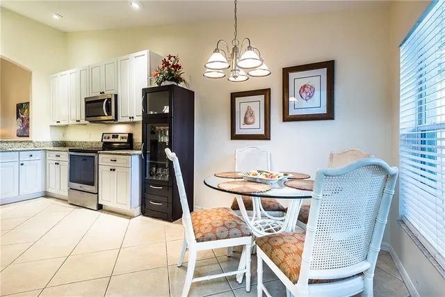 a kitchen with granite countertop a stove a sink a dining table and chairs