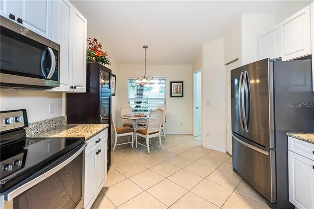a kitchen with stainless steel appliances kitchen island granite countertop a refrigerator stove and microwave