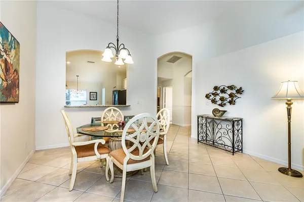 a dining room with chandelier fan and wooden floor