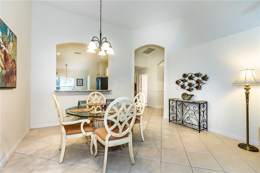 3800 Tripoli Boulevard, Unit 35 Punta Gorda, FL 33950 - Photo 18 of 44 a dining room with chandelier fan and wooden floor
