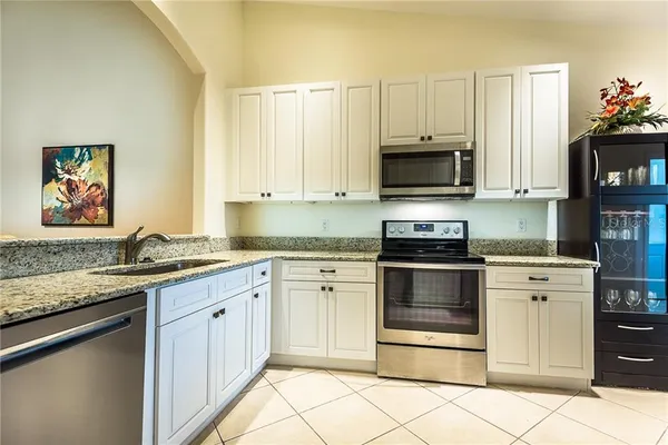 a kitchen with granite countertop a stove top oven microwave and cabinets