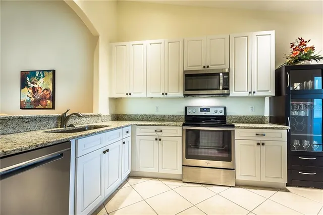 a kitchen with granite countertop a stove top oven microwave and cabinets