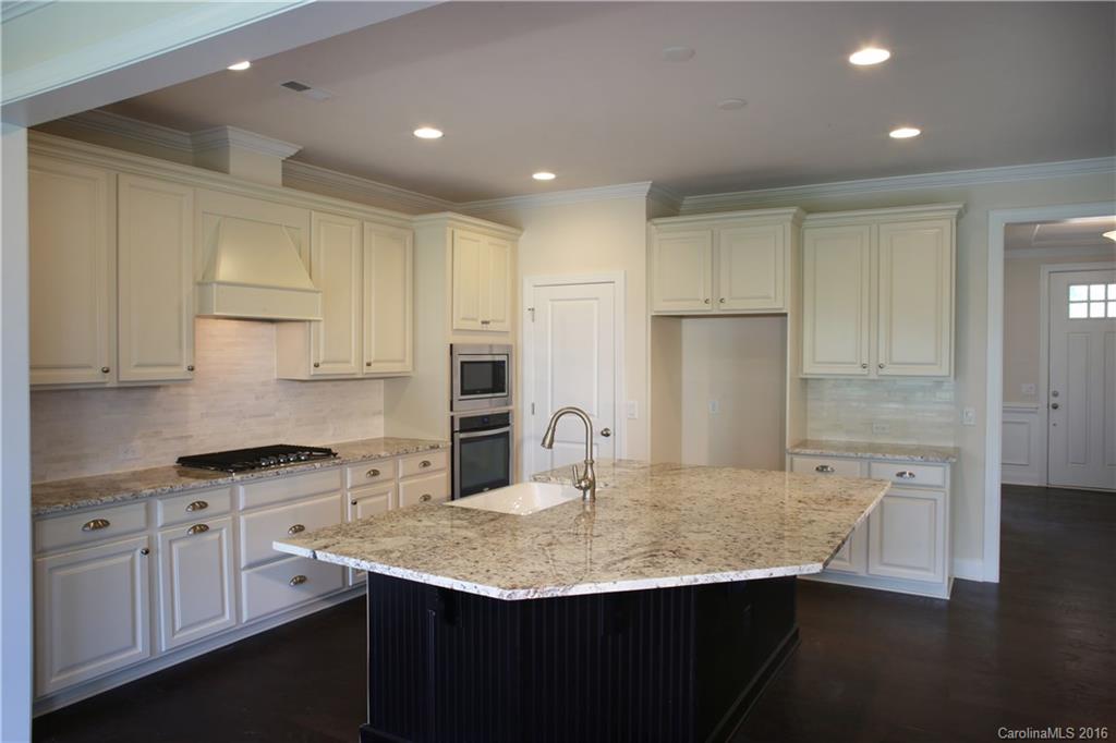 1026 Emory Lane, Unit 74 Fort Mill, SC 29708 - Photo 9 of 23 a kitchen with kitchen island granite countertop a sink cabinets and stainless steel appliances