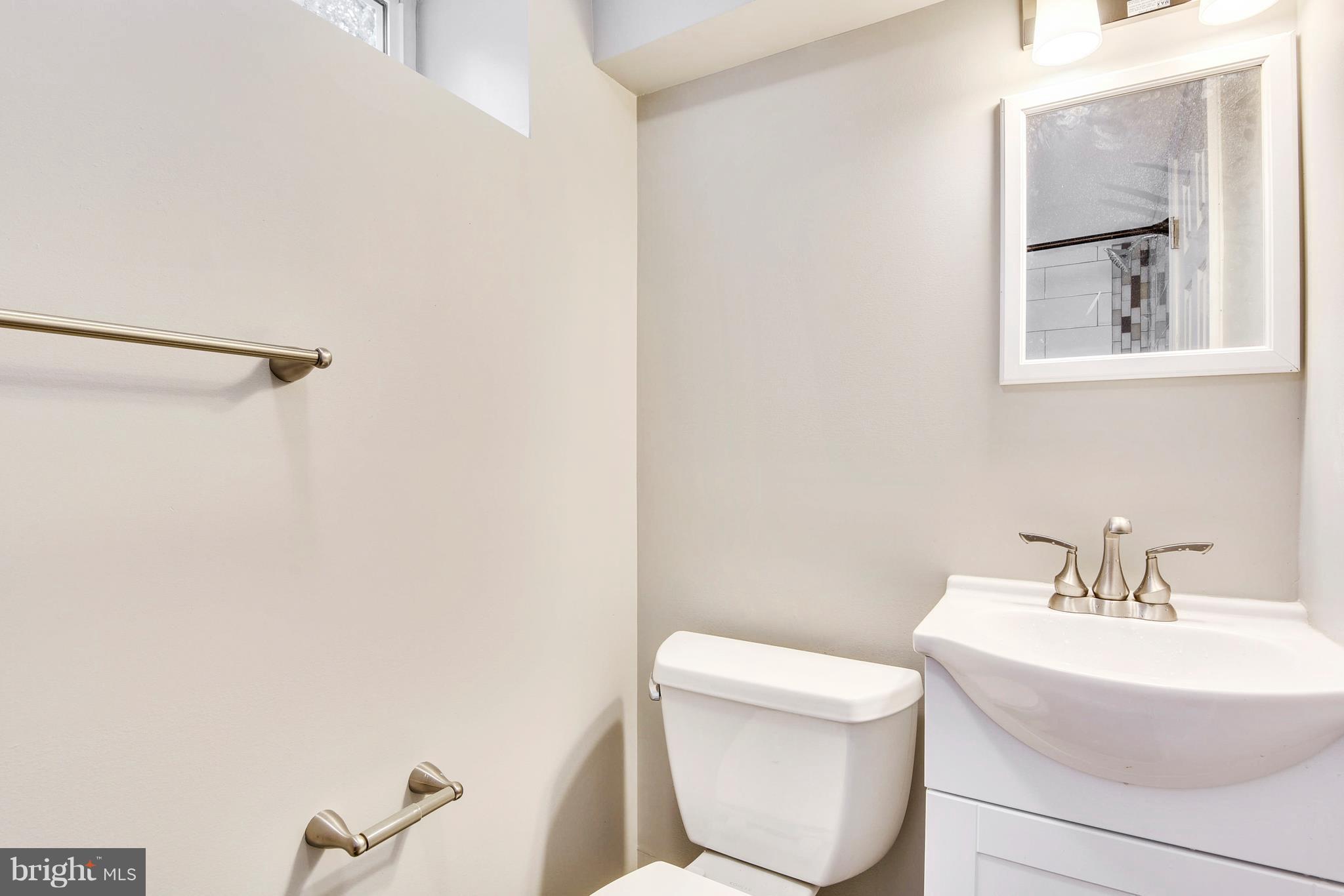 4017 Olney Laytonsville Road Olney, MD 20832 - Photo 11 of 28 a bathroom with a toilet a sink and mirror