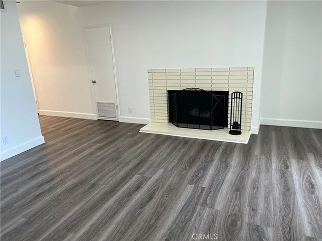 a view of a livingroom with wooden floor and a fireplace