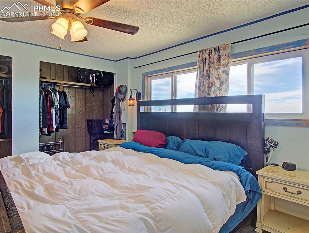 28850 Funk Road Calhan, CO 80808 - Photo 17 of 42 a bedroom with a bed and a chandelier