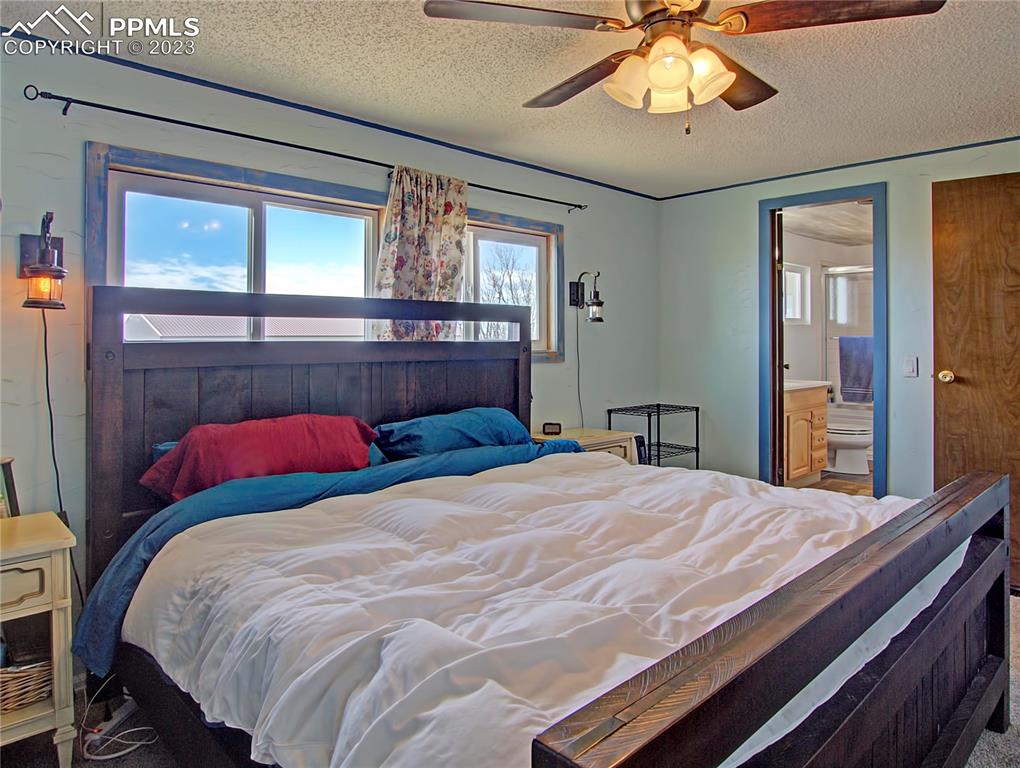 28850 Funk Road Calhan, CO 80808 - Photo 18 of 42 a bedroom with a bed and a chandelier