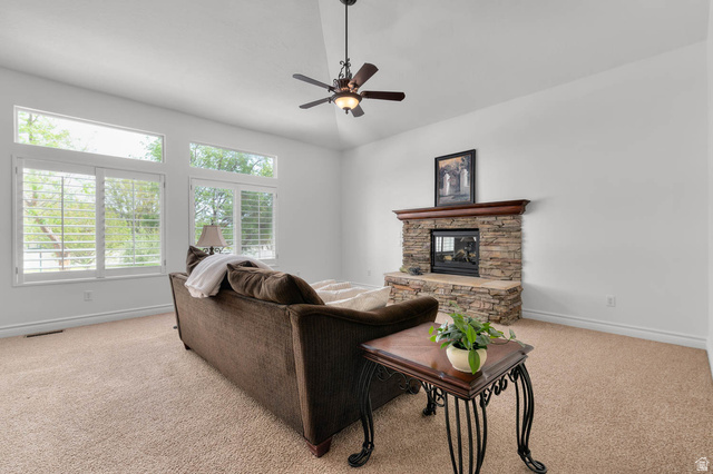 439 East 13540 South Draper, UT 84020 - Photo 6 of 46 Spacious living area featuring a stone-clad fireplace with a wood mantel, high vaulted ceilings, and a ceiling fan