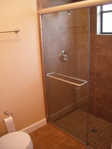 a bathroom with a granite countertop shower and a toilet