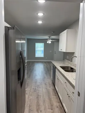 a kitchen with granite countertop a sink stove and refrigerator