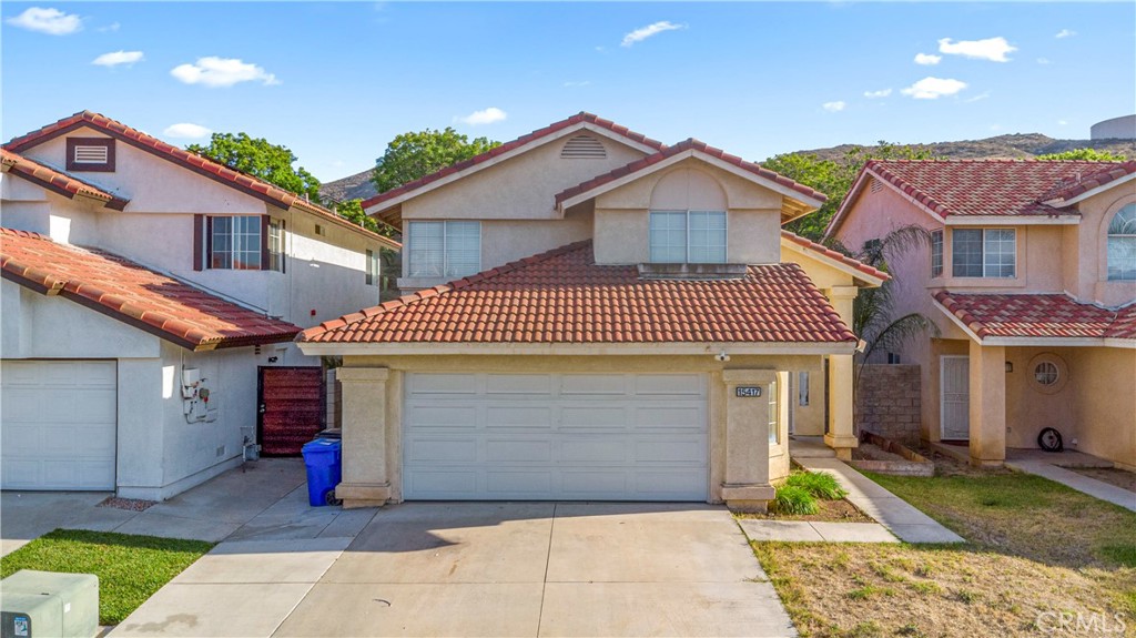 15417 Tobarra Road Fontana, CA 92337 - Photo 27 of 29 a front view of a house with a garage