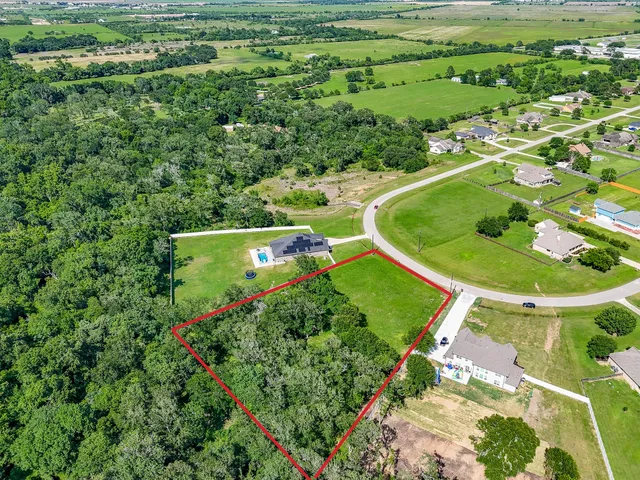 an aerial view of a residential houses with outdoor space and street view