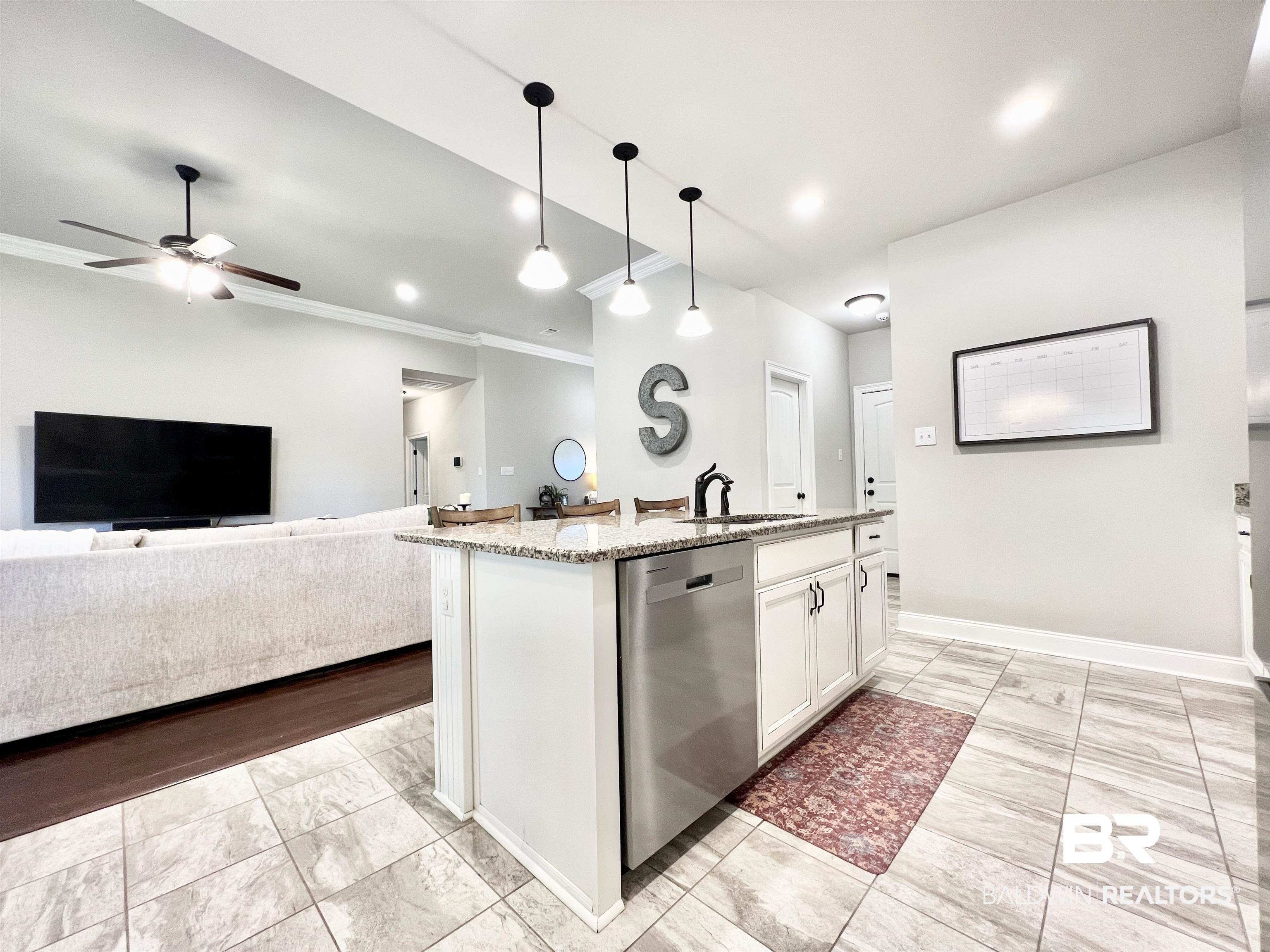32290 Calder Court Daphne, AL 36527 - Photo 17 of 59 Kitchen featuring light stone countertops, dishwasher, hanging light fixtures, white cabinets, and a kitchen island with sink
