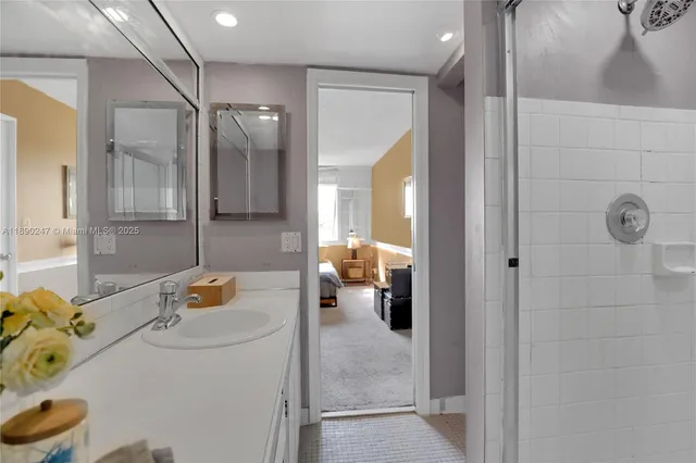 a bathroom with a tub sink and mirror