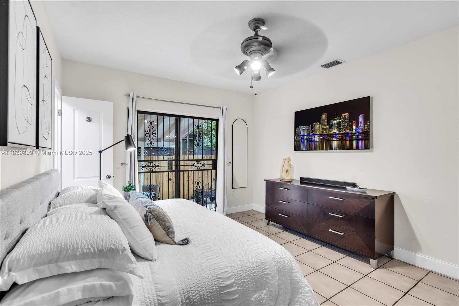 2121 Southwest 13th Avenue Miami, FL 33145 - Photo 16 of 43 a bedroom with a large bed and a flat tv screen