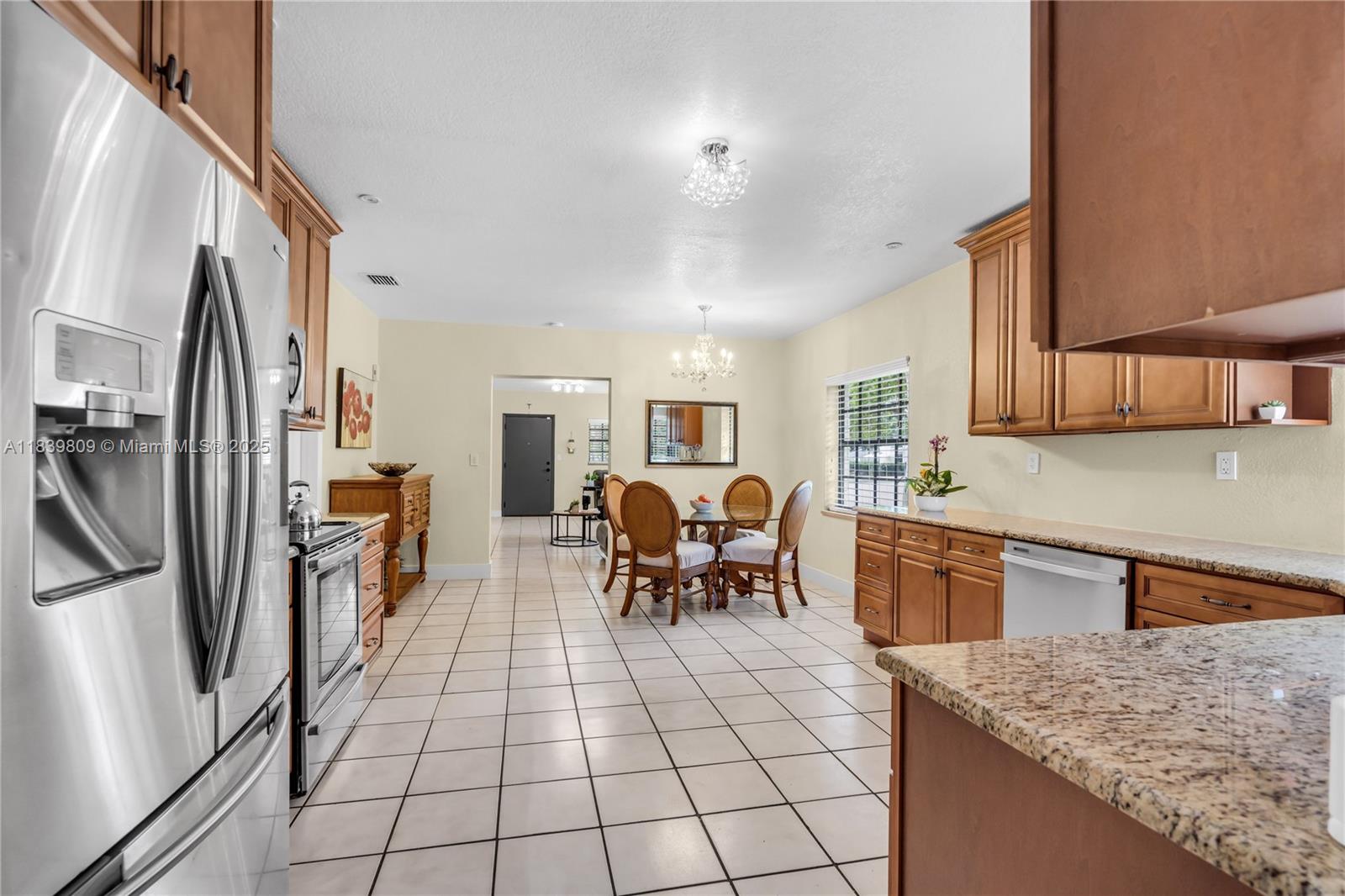 2121 Southwest 13th Avenue Miami, FL 33145 - Photo 10 of 43 a kitchen with stainless steel appliances granite countertop a refrigerator oven a sink a dining table and chairs