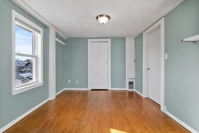 a view of a big room with wooden floor and windows