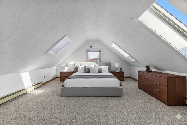 a spacious bedroom with a bed and cabinet