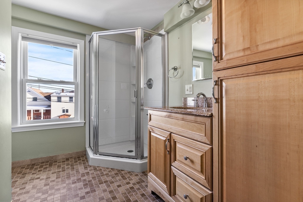 12 Wright Street, Unit 1 Stoneham, MA 02180 - Photo 28 of 36 a bathroom with a shower a sink and a mirror