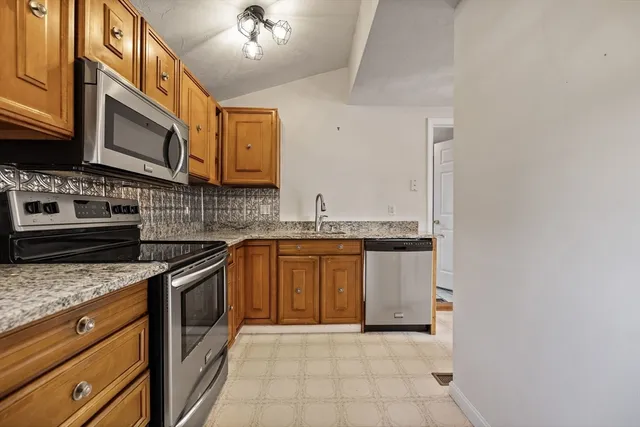a kitchen with stainless steel appliances granite countertop a stove a sink and a microwave