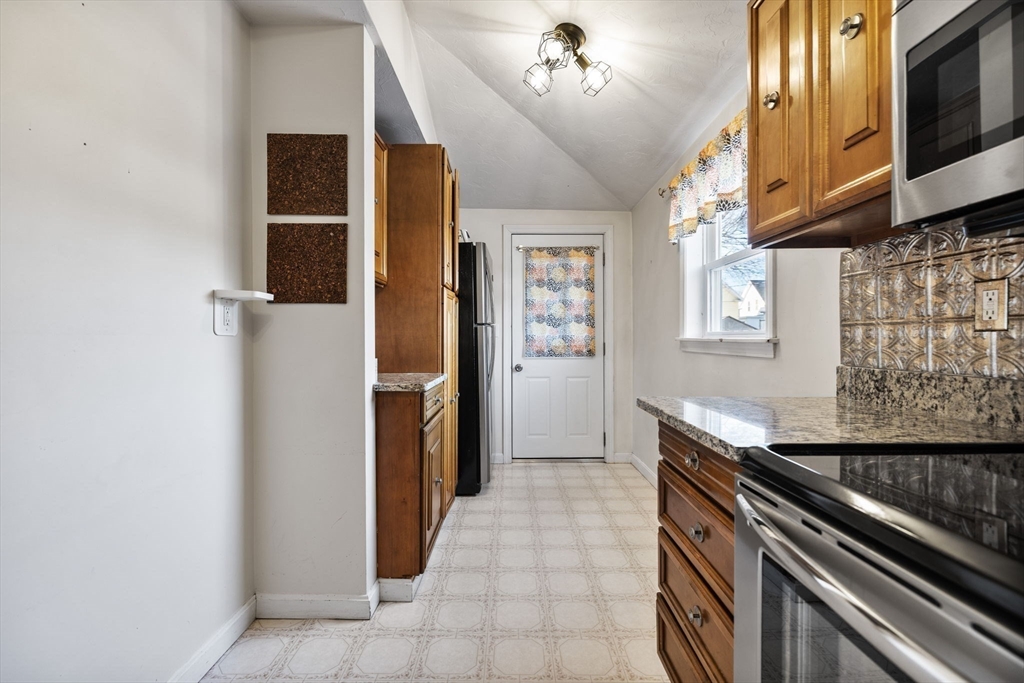 12 Wright Street, Unit 1 Stoneham, MA 02180 - Photo 10 of 36 a kitchen with stainless steel appliances granite countertop a refrigerator and a stove top oven