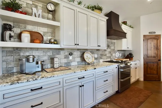 a kitchen with granite countertop white cabinets and stainless steel appliances