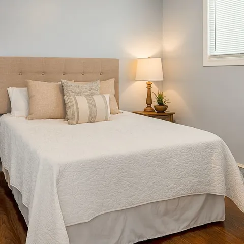 a large bed sitting in a bedroom next to a window
