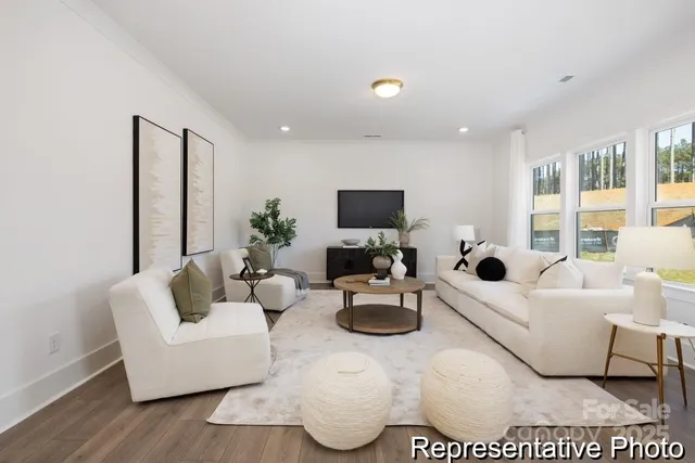 a living room with furniture a flat screen tv and a large window