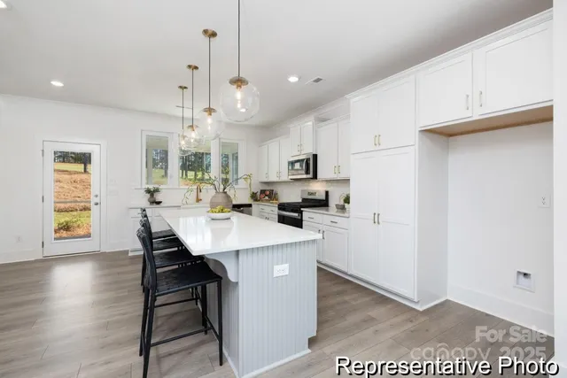a kitchen with kitchen island a stove a table and chairs