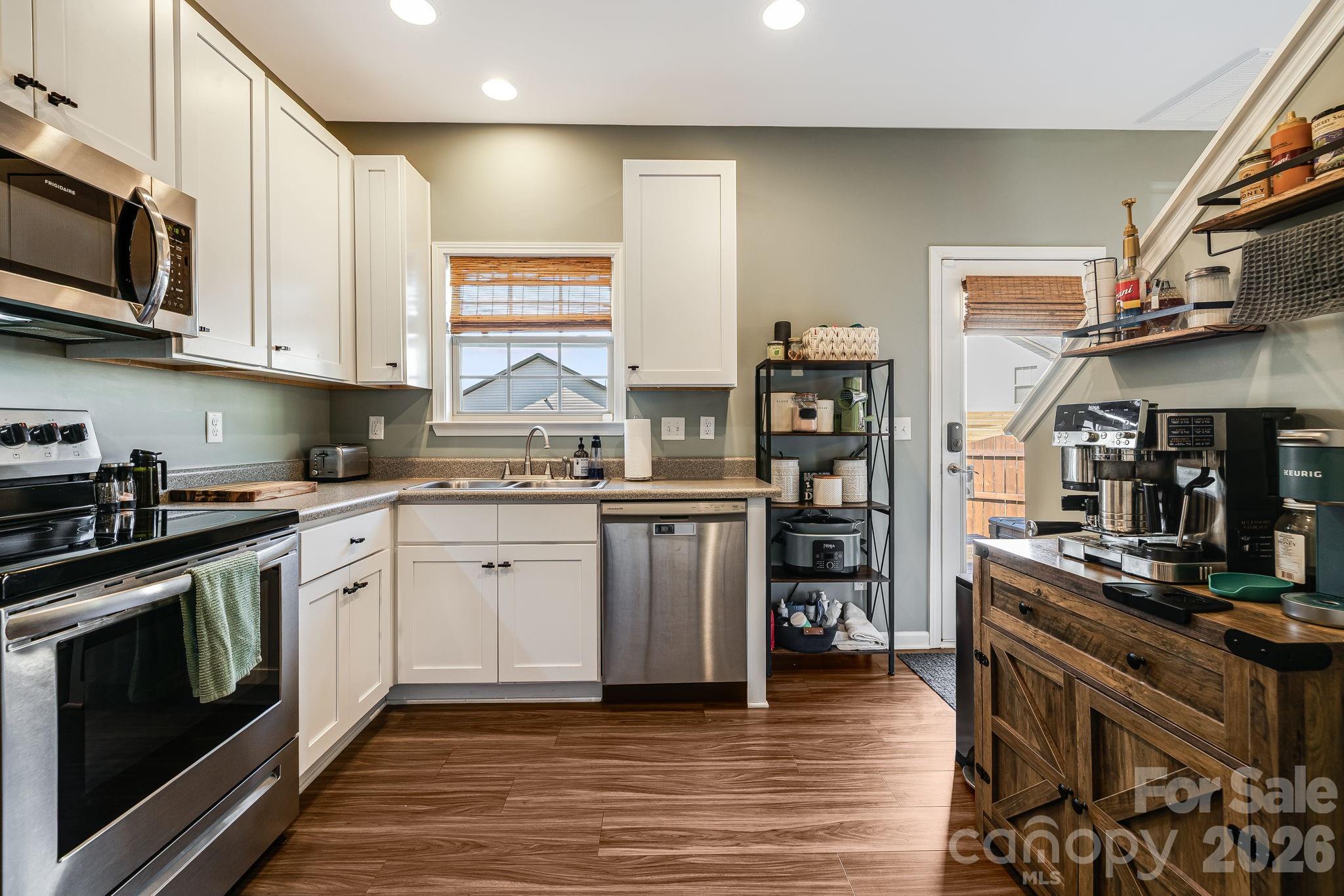 486 Cardwell Lane Fletcher, NC 28732 - Photo 12 of 35 a kitchen with stainless steel appliances granite countertop a stove top oven a sink dishwasher and cabinets with wooden floor