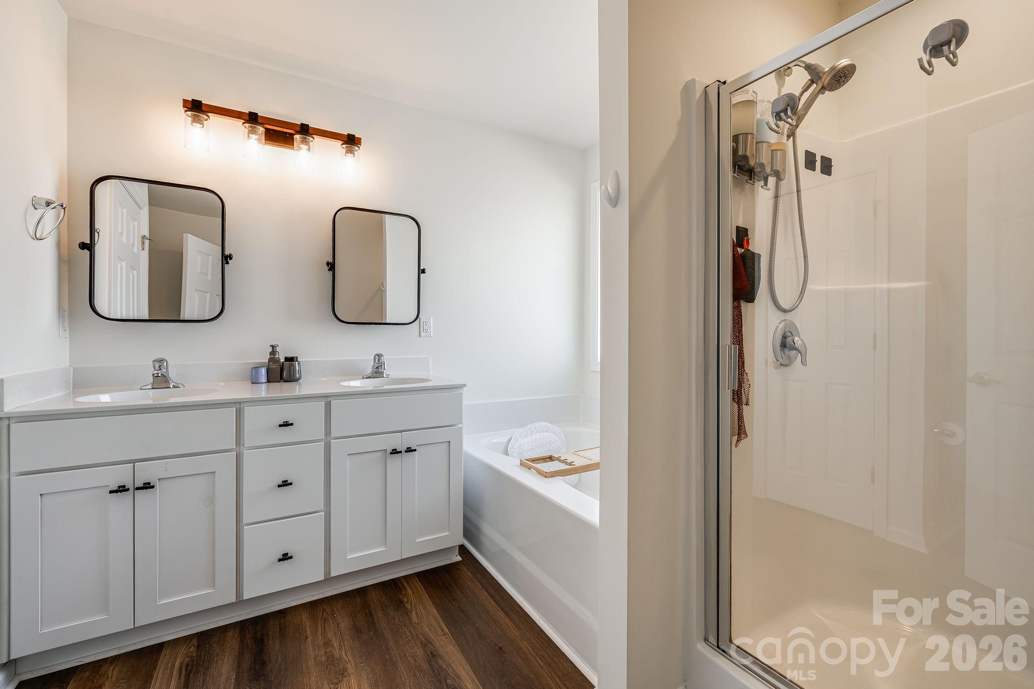 486 Cardwell Lane Fletcher, NC 28732 - Photo 18 of 35 a bathroom with a double vanity sink a mirror and a bathtub