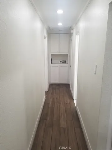 a view of a hallway with wooden floor and a floor to ceiling window