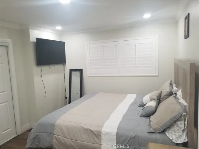 a bedroom with a bed and a flat screen tv