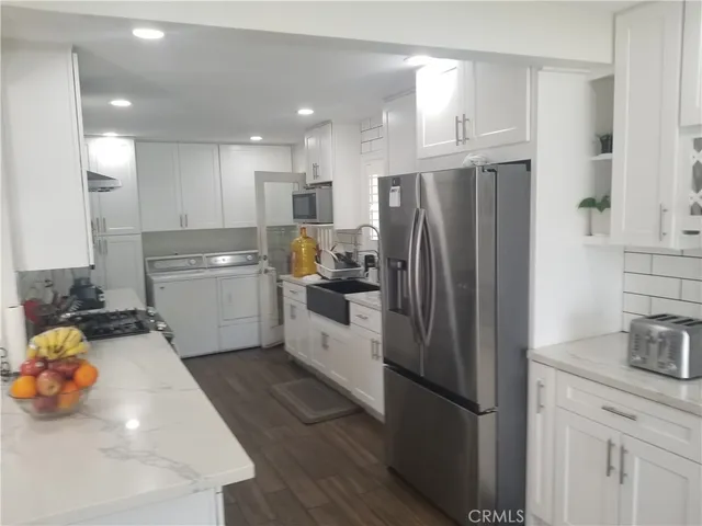 a kitchen with stainless steel appliances a refrigerator sink and cabinets
