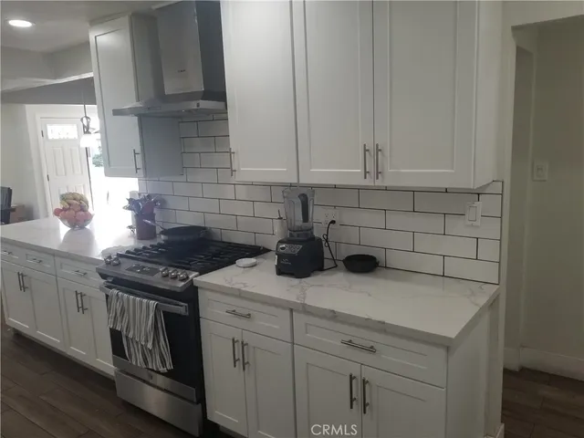 a kitchen with white cabinets and appliances