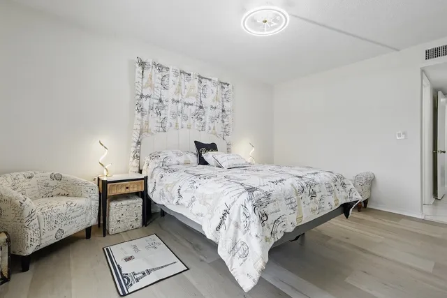 a bedroom with a bed and wooden floor