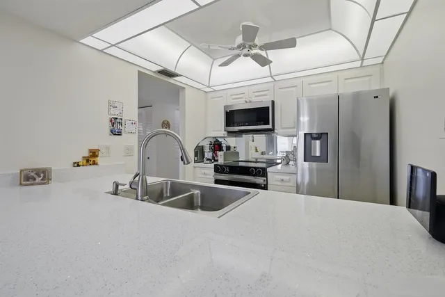 a kitchen with stainless steel appliances granite countertop a sink refrigerator and microwave