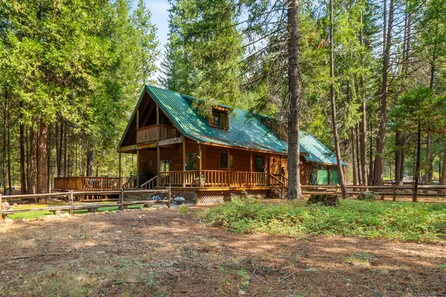 a view of a house with backyard and trees