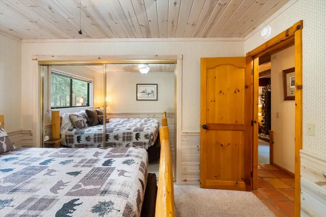 a bedroom with a bed and a dresser with mirror