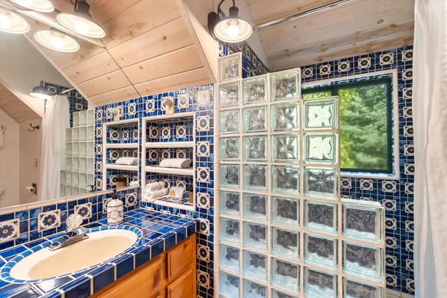 a bathroom with a granite countertop sink and a mirror