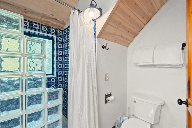 a bedroom with a bed a chandelier and flat screen tv