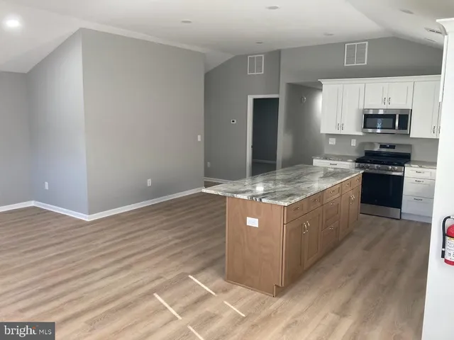 a kitchen with stainless steel appliances granite countertop a stove a refrigerator and a sink