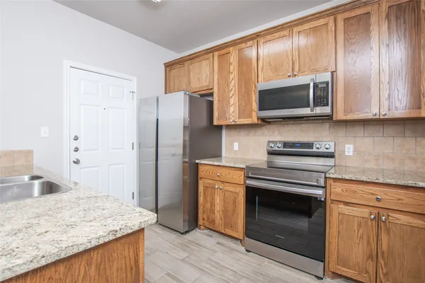 a kitchen with stainless steel appliances granite countertop a stove microwave and refrigerator