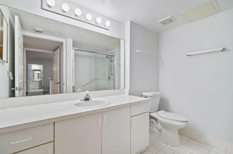 an empty room with wooden floor ceiling fan and windows