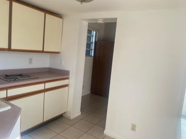 a view of a kitchen with white cabinets and a sink
