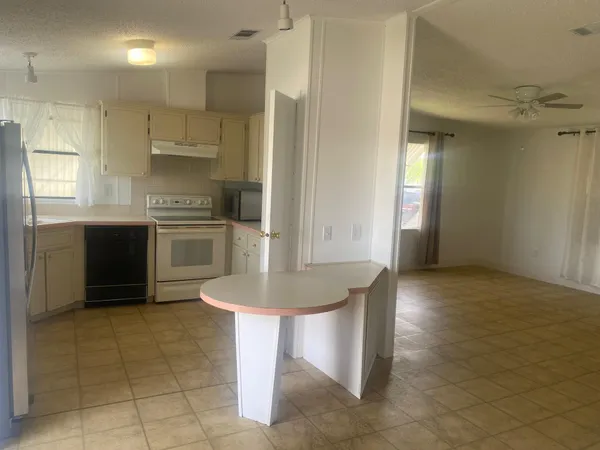 a kitchen with kitchen island granite countertop a sink cabinets and stainless steel appliances